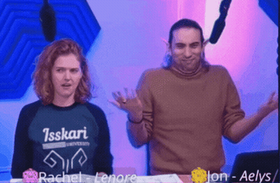 Man And Woman Standing Next To Each Other With Isskari University Shirt GIF