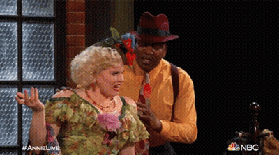 Man And Woman Standing Next To NBC Logo GIF