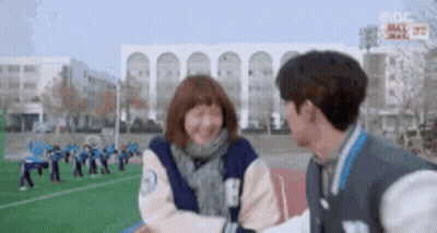 Man And Woman Standing Smiling On Field GIF