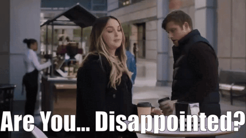 Man And Woman Standing With Are You Disappointed Behind Them GIF