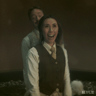 Man And Woman Standing With Netflix Logo GIF
