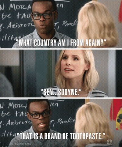 Man and Woman Talking in Front of Blackboard Saying What Country Am I From Again