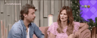Man And Woman Talking On Pink Couch GIF