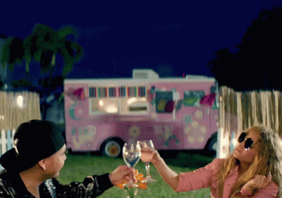Man And Woman Toasting In Front Of Pink Truck GIF