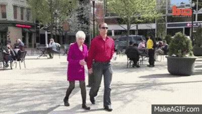 Man And Woman Walking Down City Street GIF