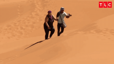 Man And Woman Walking Down Sand Dune Oh My God You're Lazy GIF