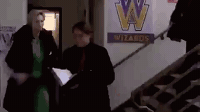 Man And Woman Walking Down Stairs Past Wizards Sign GIF