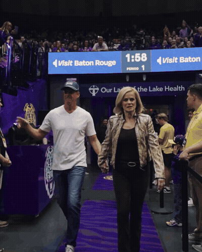 Man And Woman Walking In Front Of Baton Rouge Sign GIF