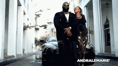 Man And Woman Walking In Front Of Black Car With Word Andralemarie GIF