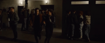 Man And Woman Walking Through Crowd In Dark Room GIF