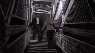 Man And Woman Walking Up Stairs Holding Hands GIF
