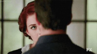 Man And Woman With Red And Green Hair Looking At Each Other GIF