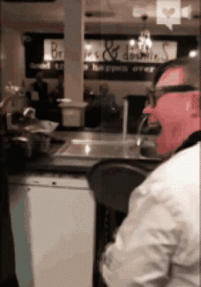 Man At Counter With Bread & Donuts Sign GIF