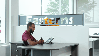 Man At Desk In Front Of Easterns Sign GIF