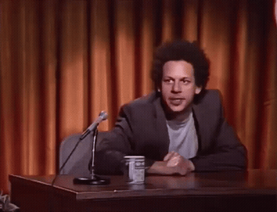 Man At Desk With Hands In Air GIF