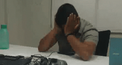 Man At Desk With Hands On Face GIF