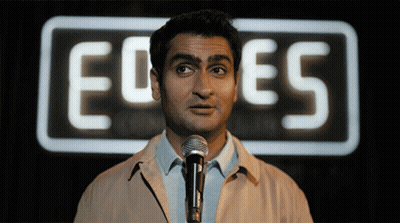 Man At Microphone In Front Of Ed Es Sign GIF