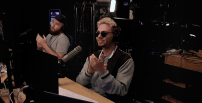 Man At Microphone In Front Of The Podcast Sign GIF