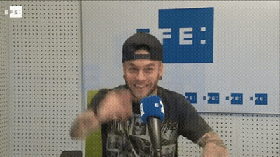 Man At Microphone In Front Of Wall Saying Fe GIF