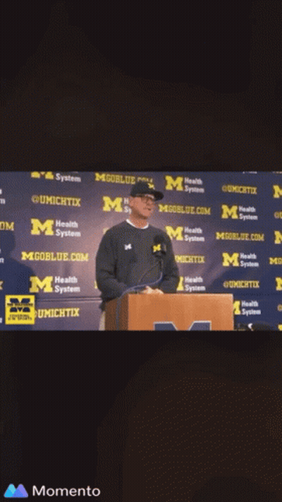 Man at Podium With mgoblue.com Wall