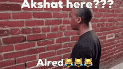 Man At Red Brick Wall Says Akshit Here GIF