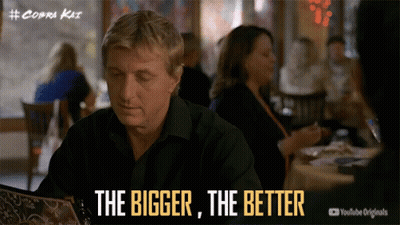 Man At Table Saying The Bigger The Better GIF