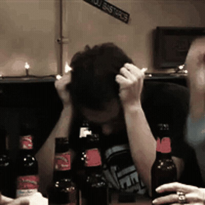 Man At Table With Beer And You Bastards Sign GIF
