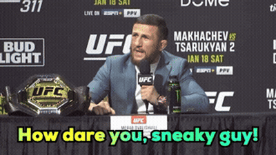 Man At Table With Microphone In Front Of UFC Sign GIF