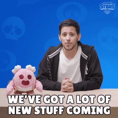 Man At Table With Stuffed Animal Saying We've Got A Lot Of New Stuff Coming GIF