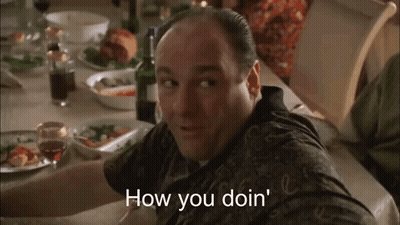 Man At Table With Wine Bottle And Plates Of Food GIF