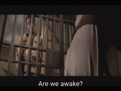 Man Behind Bars Jail Cell Are We Awake GIF
