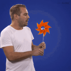 Man Blowing Hand Held Windmill GIF