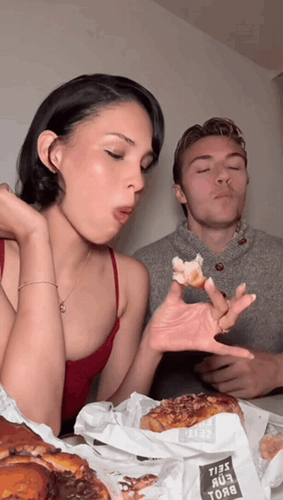 Man Blowing Kiss To Woman Eating Donuts GIF