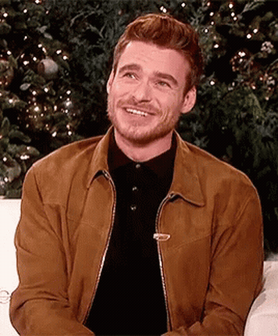 Man Brown Jacket Black Shirt Smiling On Couch GIF