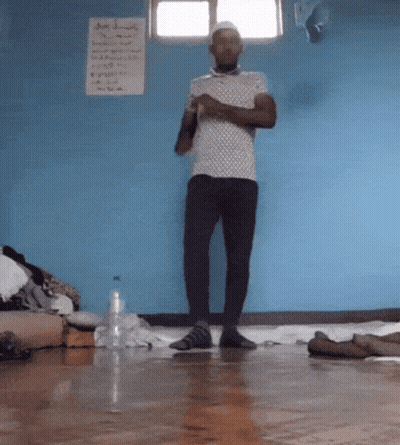 Man By Blue Wall With A Sign GIF