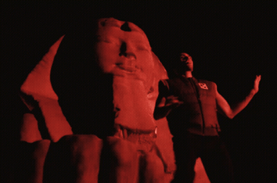 Man By Red-Lit Statue GIF