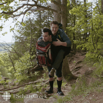 Man Carrying Another Man On His Back In Woods GIF