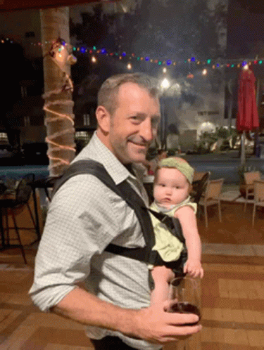 Man Carrying Baby Holding Glass of Wine