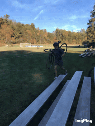 Man Carrying Bike Across Bleacher Field Imgplay GIF