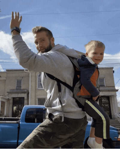 Man Carrying Child On Back In Front Of Blue Truck V8 GIF