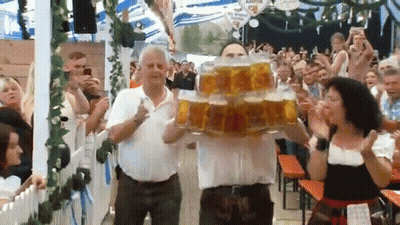 Man Carrying Stack Of Beer Mugs In Front Of Crowd GIF