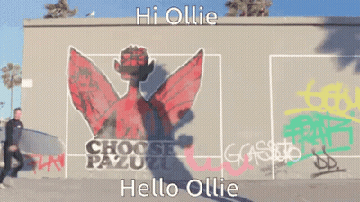 Man Carrying Surfboard In Front Of Hoose Pazuzu Mural GIF