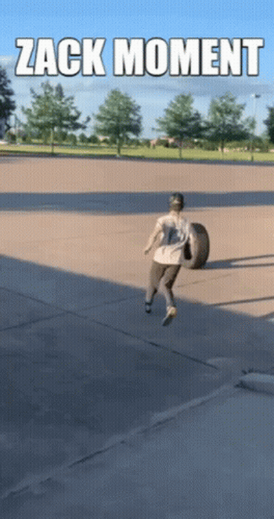 Man Carrying Tire in Parking Lot