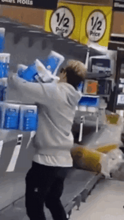Man Carrying Toilet Paper Rolls In Store GIF