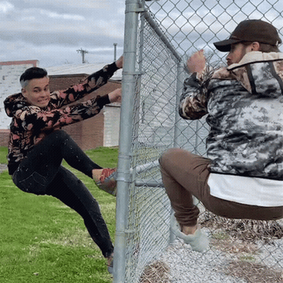 Man Climbing Chain Link Fence, Another Squats
