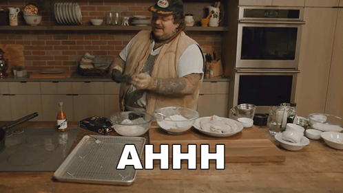 Man Cooking In Kitchen With Ahhh On Counter GIF