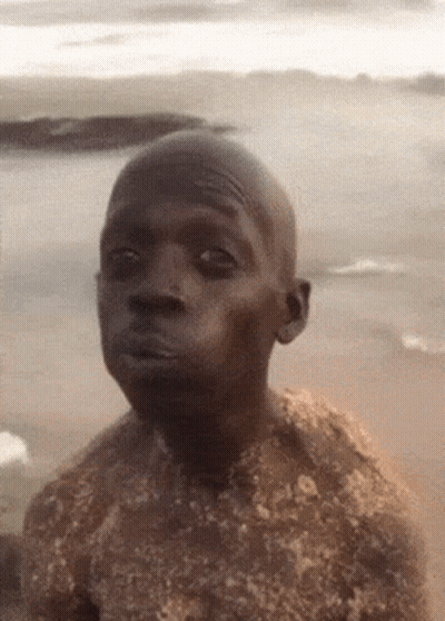 Man Covered In Sand Looking Seriously At Camera GIF