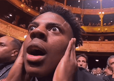 Man Covering Ears In Crowded Theater GIF