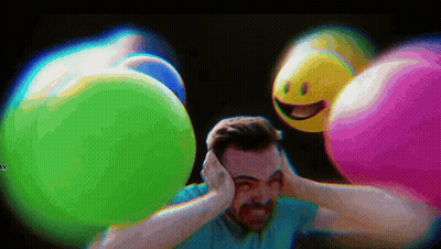 Man Covering Ears In Front Of Colorful Balloons GIF