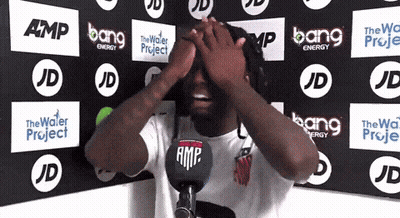 Man Covering Eyes In Front Of Bang Energy Wall GIF